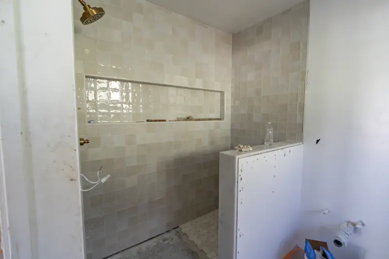 Primary walk-in shower tiled with a long niche